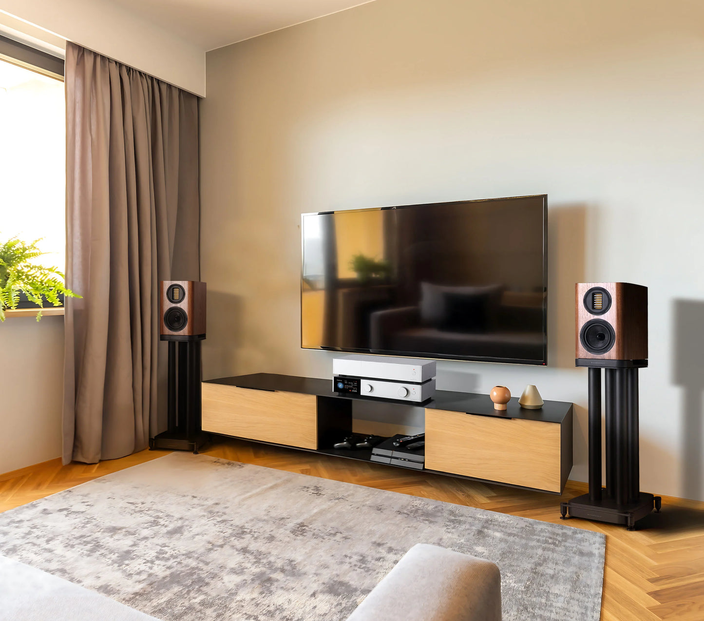 Modern living room with a television on a wooden stand, flanked by a pair of of EVO 5.1 speakers. in walnut finish on black EVO stands.
