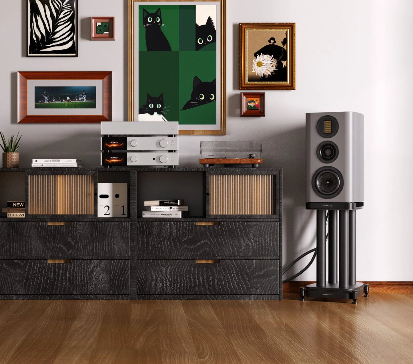 Modern interior with a black cabinet, speakers, and framed pictures on a wall.