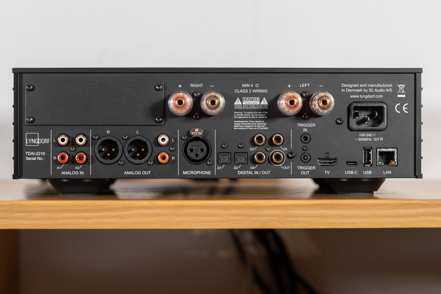 Rear panel of the Lyngdorf TDAI-2210 showing HDMI 2.1, USB-C, digital and analog inputs/outputs, RoomPerfect microphone input, speaker terminals, and Ethernet port.