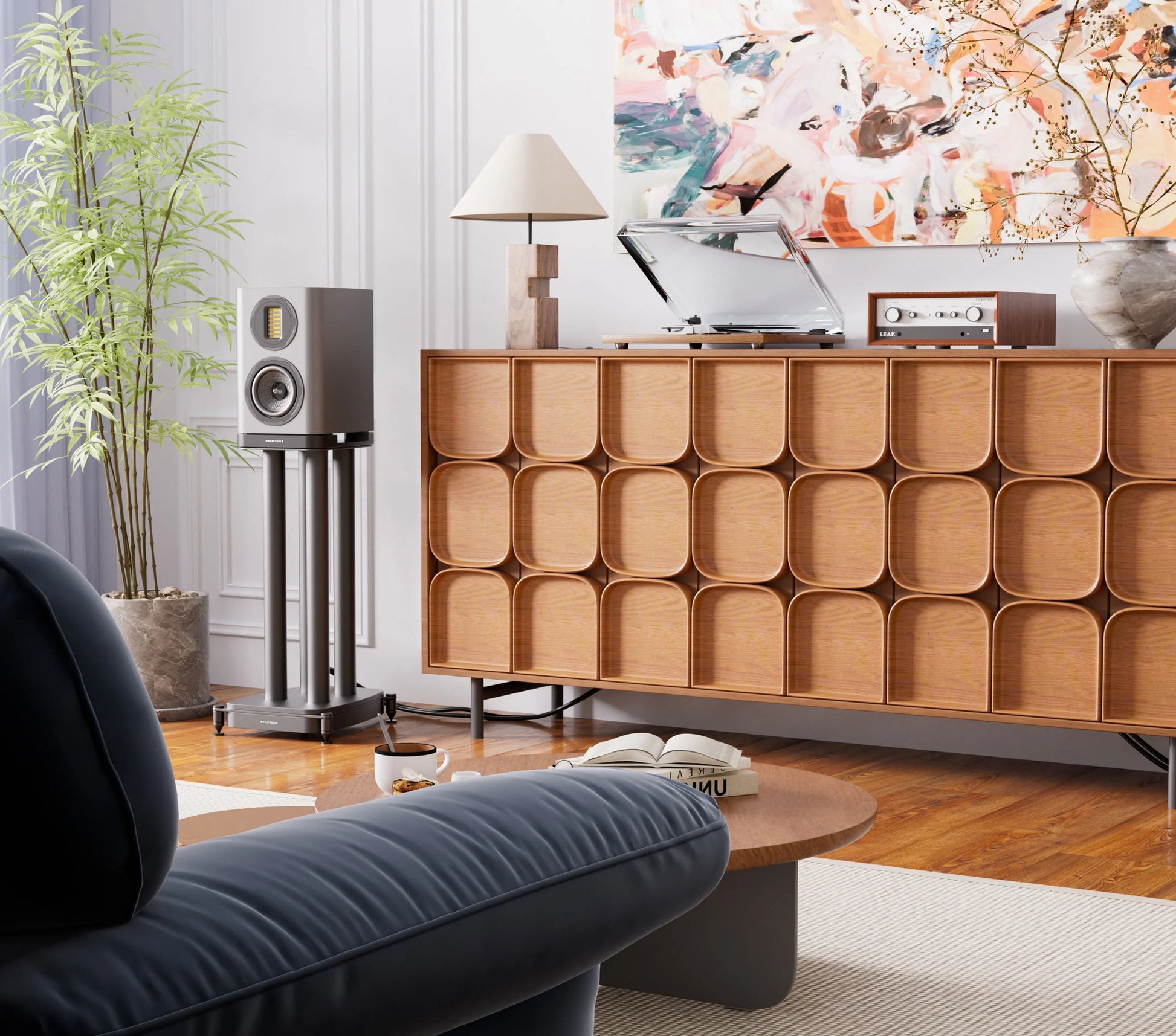Shows the EVO 5.1, grey finish, in situation. It is in a modern living room with wooden sideboard, gray sofa, and decorative elements.